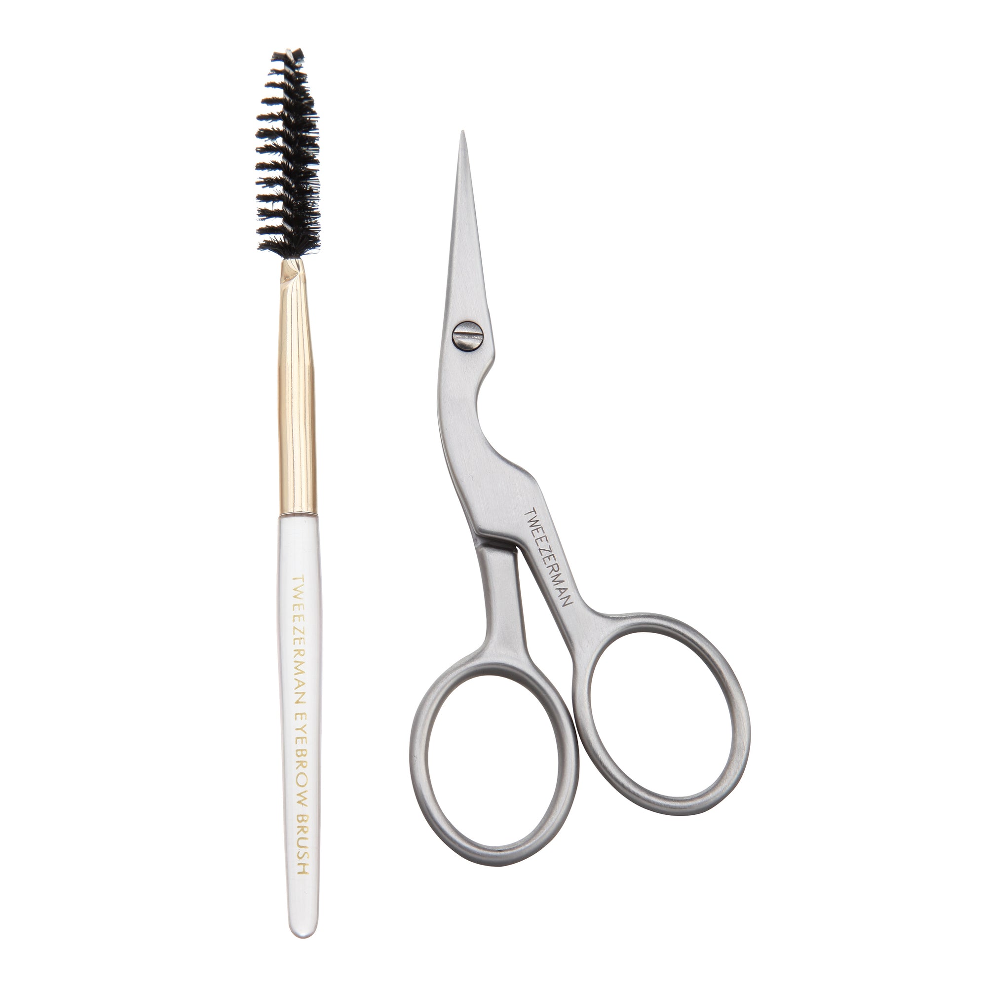 Brow shaping brush with white handle, gold ferrule, black spoolie brush head "Tweezerman Eyebrow Brush" in gold coloring written on brush handle. Stainless steel brow shaping scissors with contoured body and loop handles "Tweezerman Italy" written on scissors.