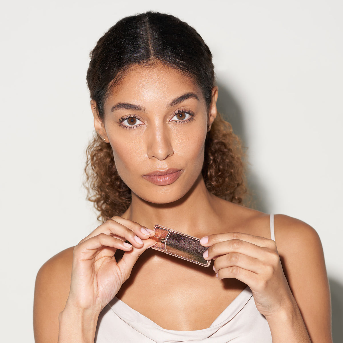 Model holding Rose Gold mini Slant Tweezer and Case